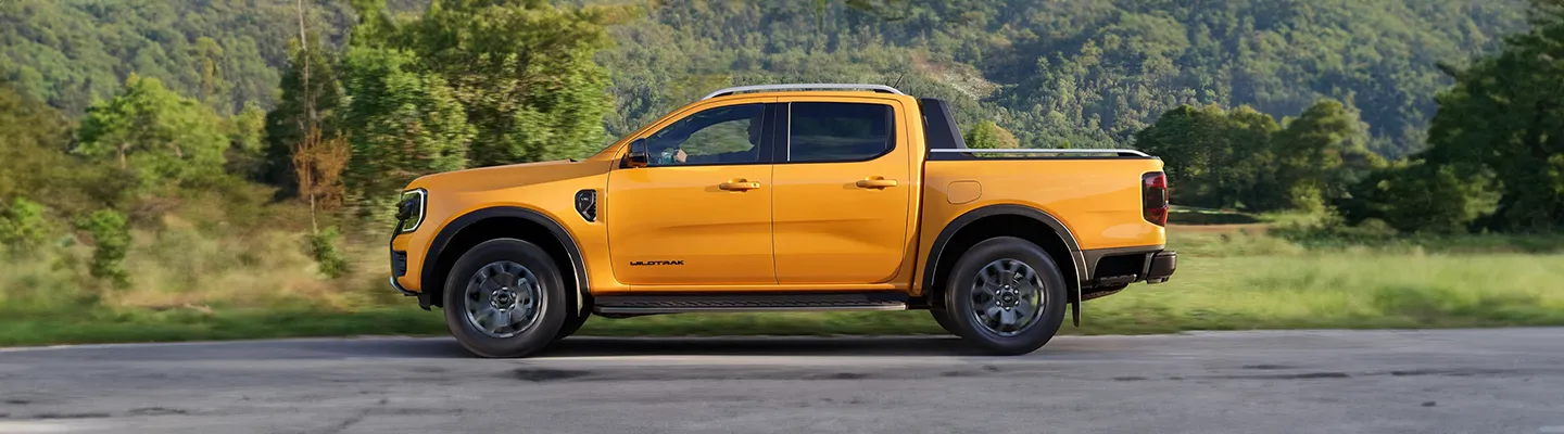 Doğada yol alan sarı Ford Ranger yandan görünüm