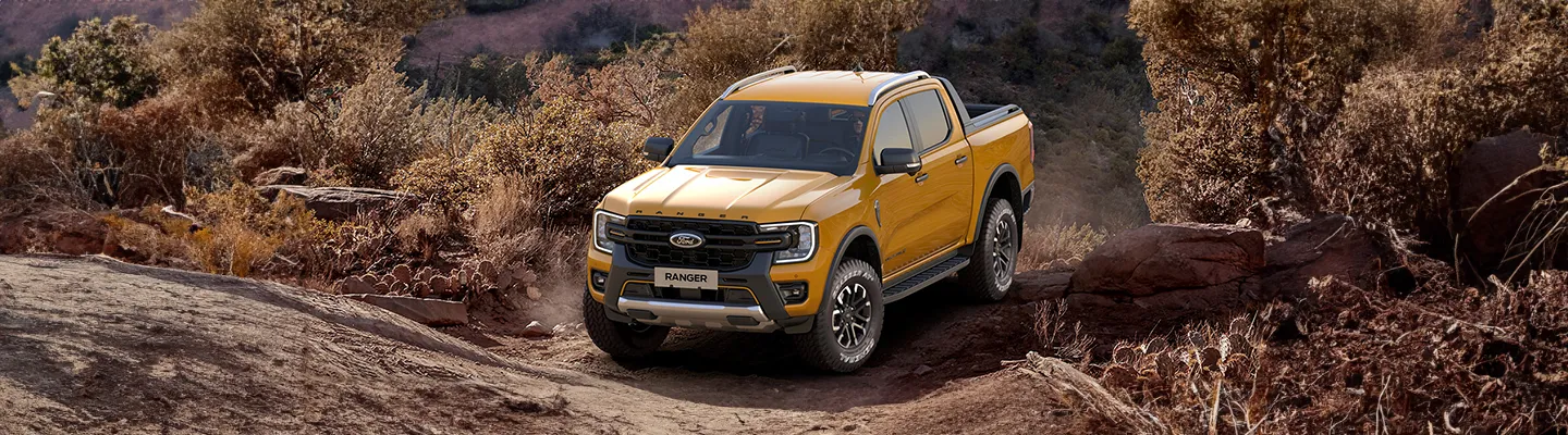 Kayalık arazide ilerleyen sarı Ford Ranger pick-up